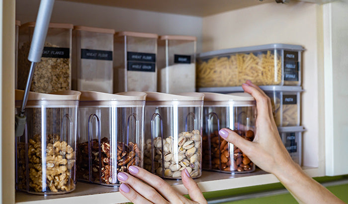 A woman reaching into a cabinet filled with freeze dried food