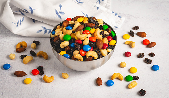 Assorted nuts and candies in a decorative bowl, ideal for a quick treat.