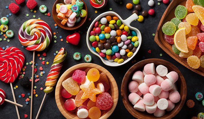 Various candies and sweets in colorful bowls